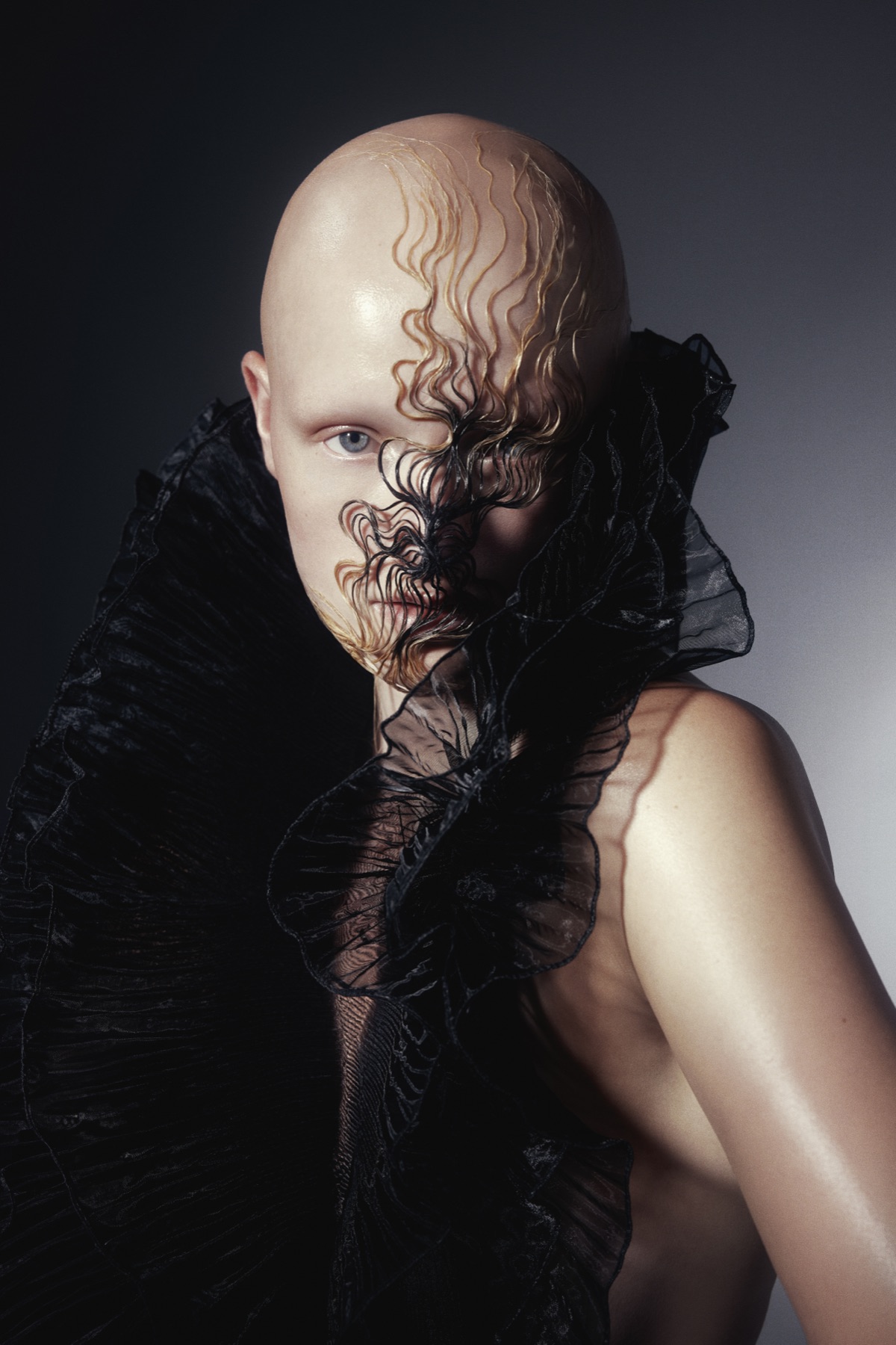 Avant-garde sculpted hair styling with black ruffled collar