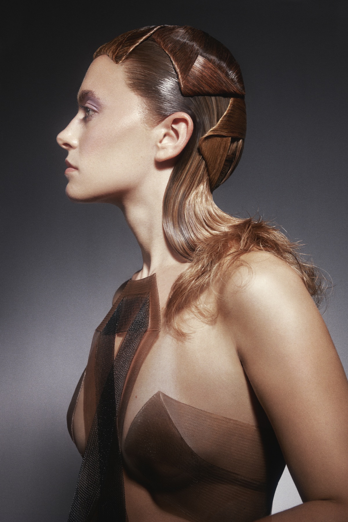 Woven side-swept sculptural hair styling, profile view