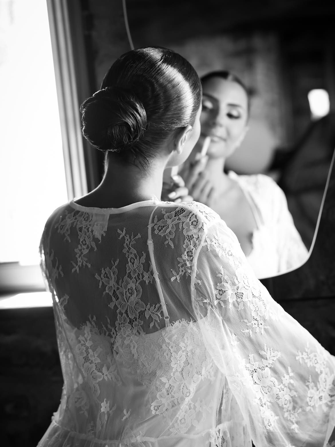 Bride's sleek low bun reflected in mirror, black and white, Cilento, Italy