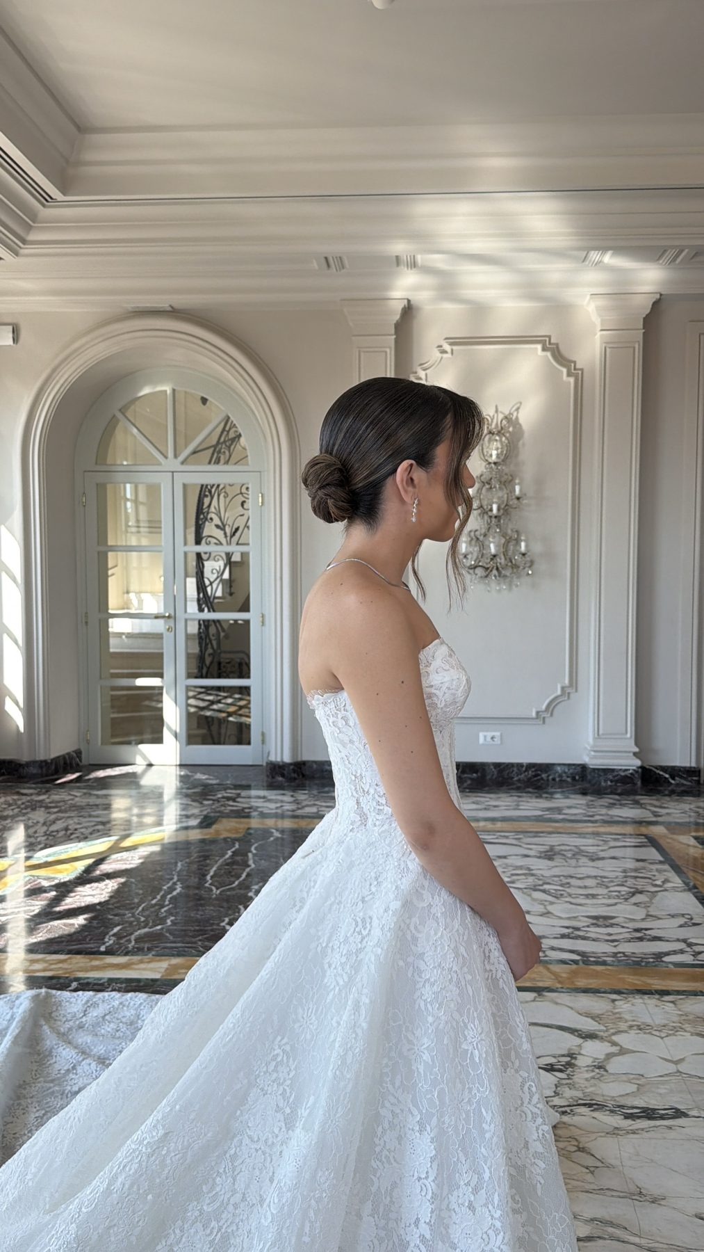 Close-up profile of bride's sleek low bun, villa in Italy
