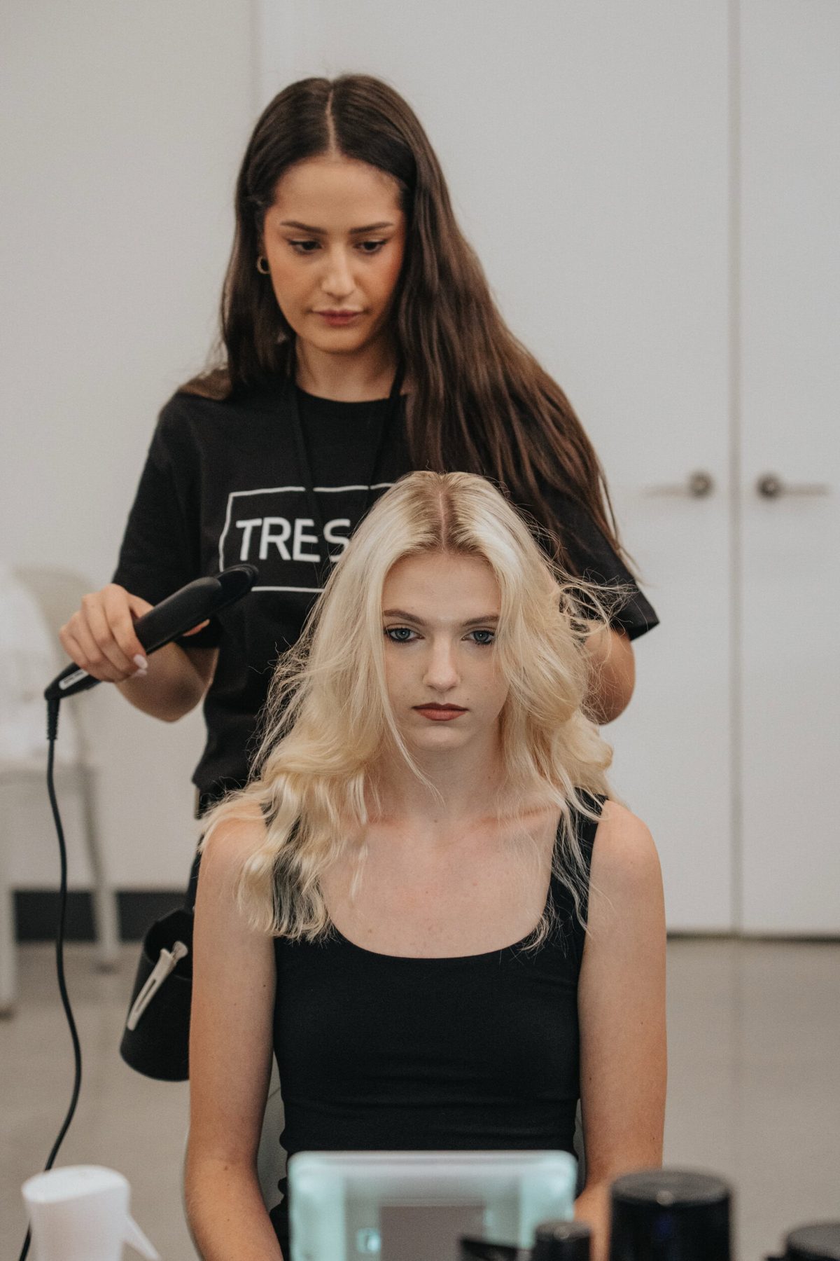 Stylist finishing a model's blonde waves backstage, Christian Cowan Spring 2027 show